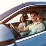 Happy family traveling by car on summer day