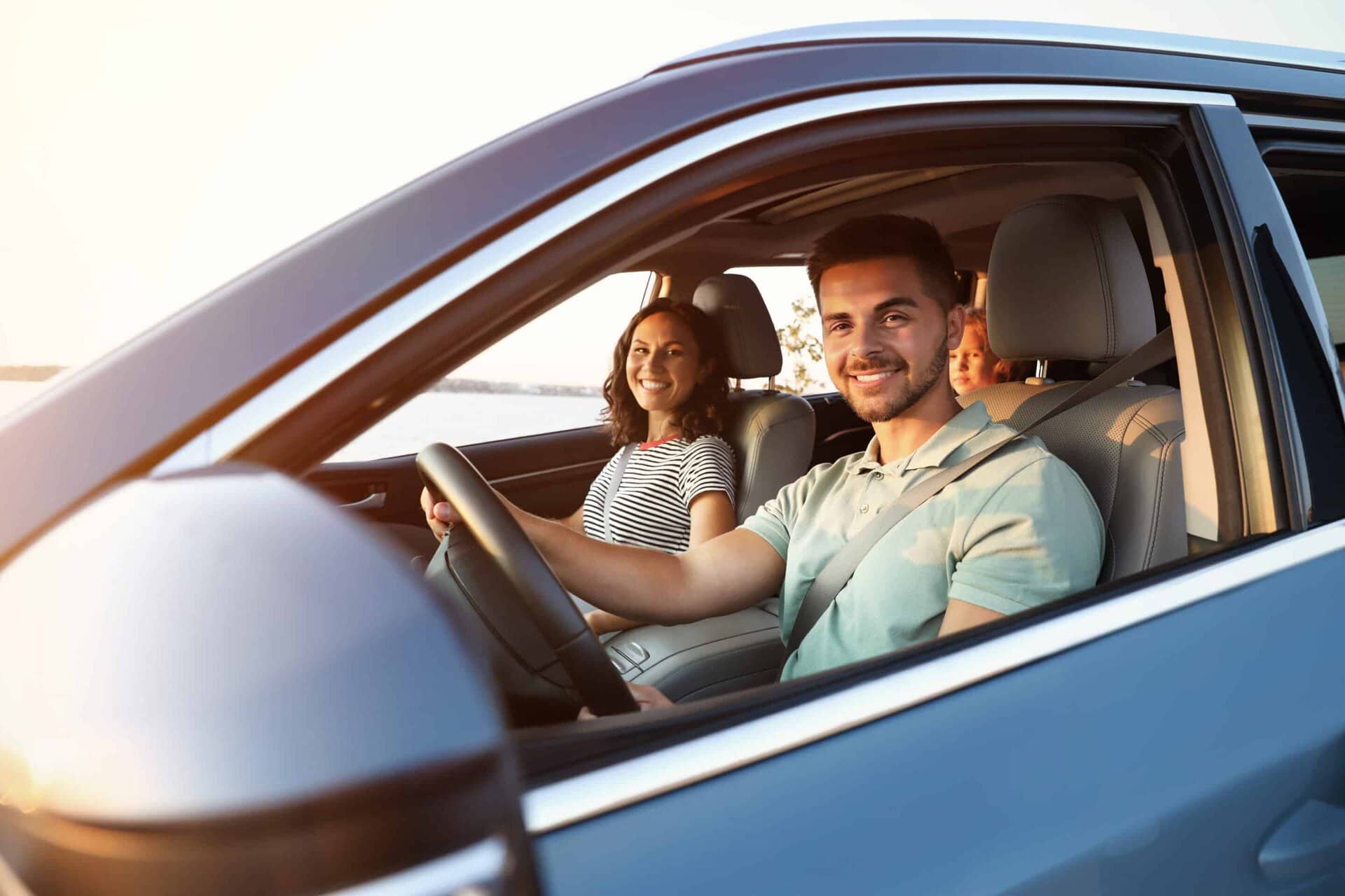 Happy family traveling by car on summer day